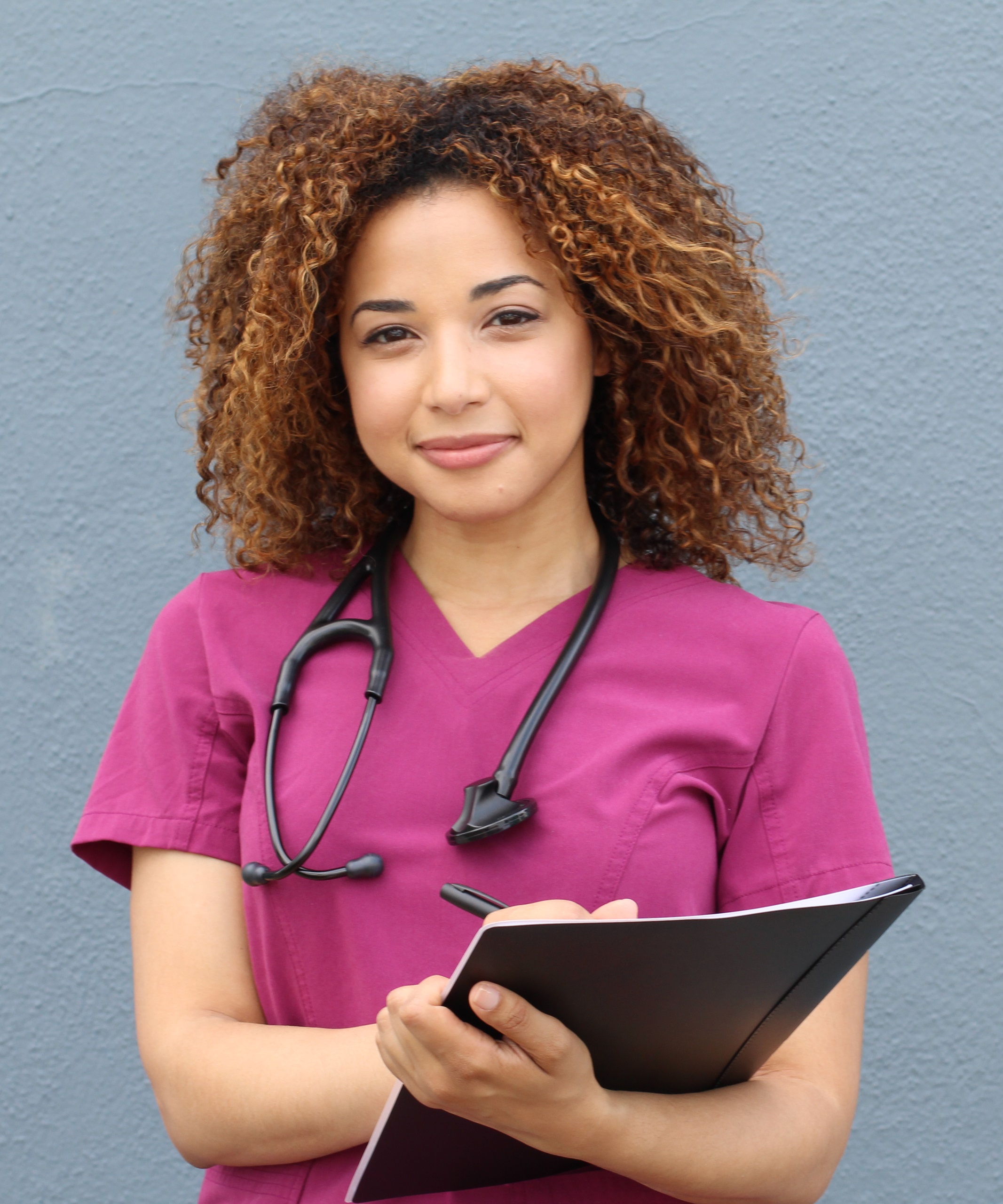 female medical professional in front of a blank wall